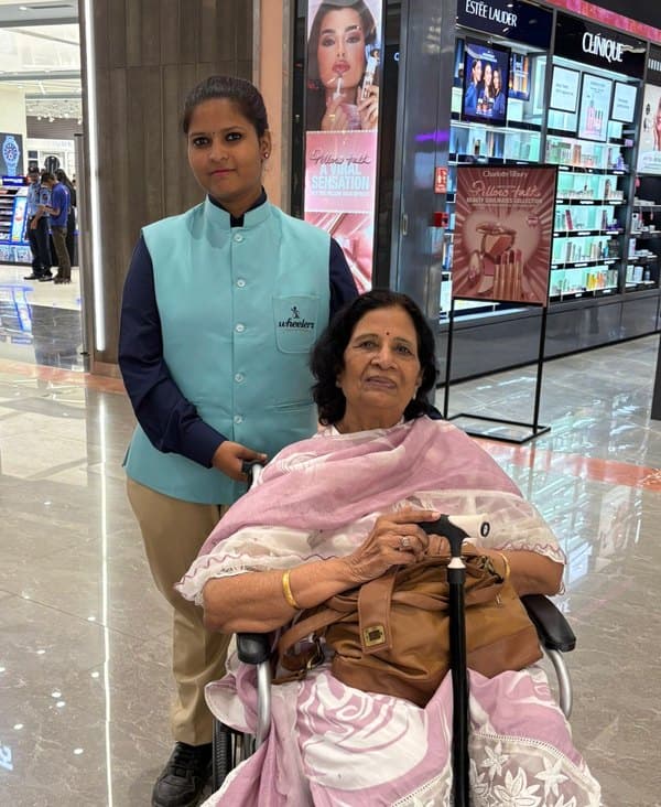 A Wheelerz attendant with a guest in a wheelchair in the mall
